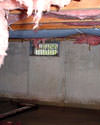 Saskatchewan crawl space with vents, showing mold, rot, and fiberglass insulation dripping off the ceiling.