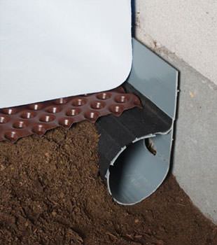 Closeup of a crawl space drainage system installed in Lanigan